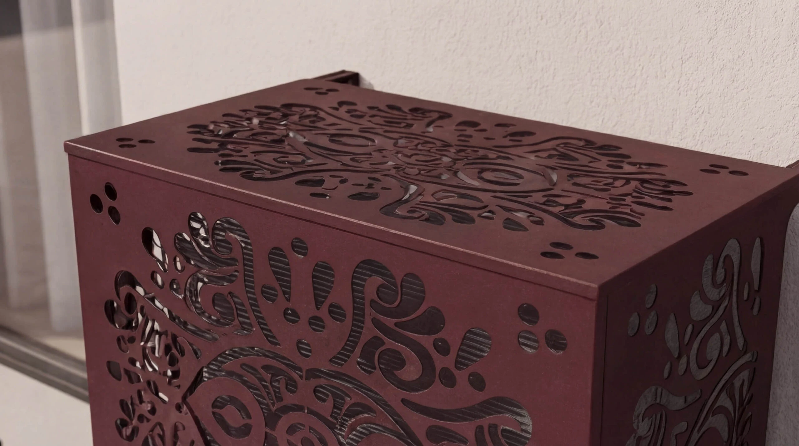 Cache climatisation extérieur design en métal découpé avec motifs décoratifs pour dissimuler une unité extérieure de climatisation.